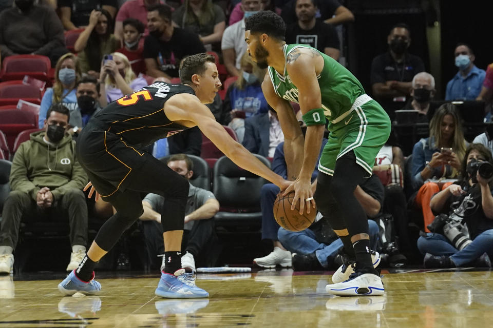 Miami Heat guard Duncan Robinson (55) defends Boston Celtics forward Jayson Tatum (0) during the first half of an NBA basketball game, Thursday, Nov. 4, 2021, in Miami. (AP Photo/Marta Lavandier)