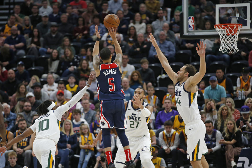 Washington Wizards guard Shabazz Napier (5) shoots as Utah Jazz's Mike Conley (10), Rudy Gobert (27) and Bojan Bogdanovic (44) defend in the first half during an NBA basketball game Friday, Feb. 28, 2020, in Salt Lake City. (AP Photo/Rick Bowmer)