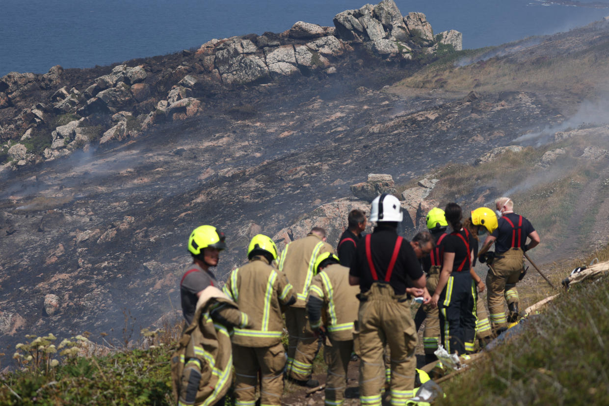 Firefighters attend a gorse bush fire, during a heatwave near Zennor, Cornwall, Britain, July 19, 2022. REUTERS/Tom Nicholson