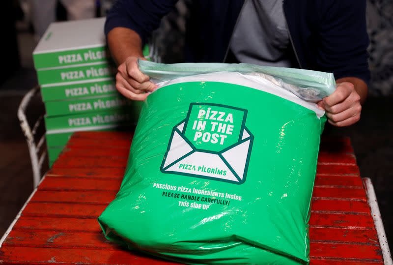 Co-founder of Pizza Pilgrims, James Elliot, demonstrates the packing of a Pizza in the Post kit in one of their restaurants amid the coronavirus disease (COVID-19) outbreak in London