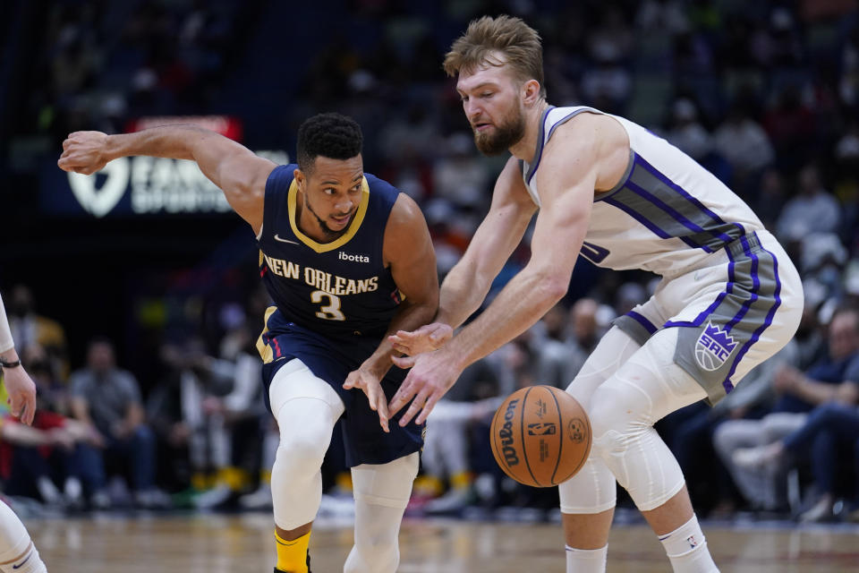 New Orleans Pelicans guard CJ McCollum (3) chases a loose ball against Sacramento Kings forward Domantas Sabonis in the second half of an NBA basketball game in New Orleans, Wednesday, March 2, 2022. The Pelicans won 125-95. (AP Photo/Gerald Herbert)