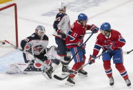 Montreal Canadiens right wing Jesse Ylonen, not shown, scores on Columbus Blue Jackets goaltender Elvis Merzlikins (90) as Canadiens right wing Brendan Gallagher (11) and center Jake Evans (71) screen the shot in front of Blue Jackets defenseman Gavin Bayreuther (15) during the first period of an NHL hockey game in Montreal, Saturday, March 25, 2023. (Peter McCabe/The Canadian Press via AP)