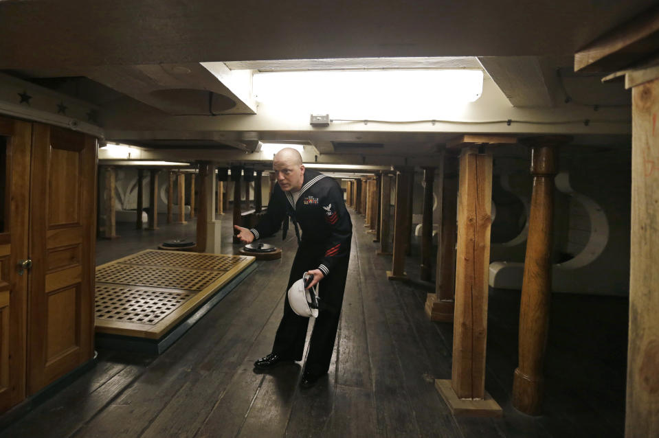 Public Affairs Officer Josh Hammond ducks down in the crew sleeping quarters below deck on the USS Constitution, Wednesday, April 5, 2017, at the Charlestown Navy Yard in Boston. The ship enters dry dock for below-the-waterline repairs every 20 years. The world's oldest commissioned warship afloat is scheduled to return to the waters in late July. (AP Photo/Elise Amendola)