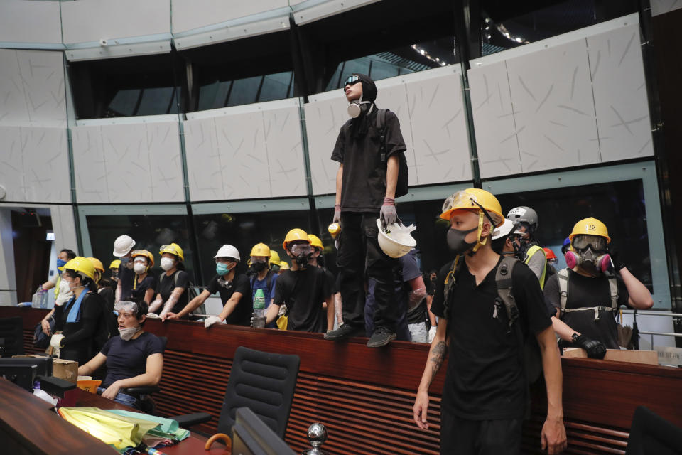 Protesters gather inside the meeting hall of the Legislative Council in Hong Kong, Monday, July 1, 2019. Protesters in Hong Kong took over the legislature's main building Friday night, tearing down portraits of legislative leaders and spray painting pro-democracy slogans on the walls of the main chamber.(AP Photo/Kin Cheung)