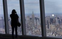A woman photographs the Manhattan skyline from the One World Observatory observation deck on the 100th floor of the One World Trade center tower in New York during a press tour of the site May 20, 2015. One World Observatory will open to the public on May 29. (REUTERS/Mike Segar)