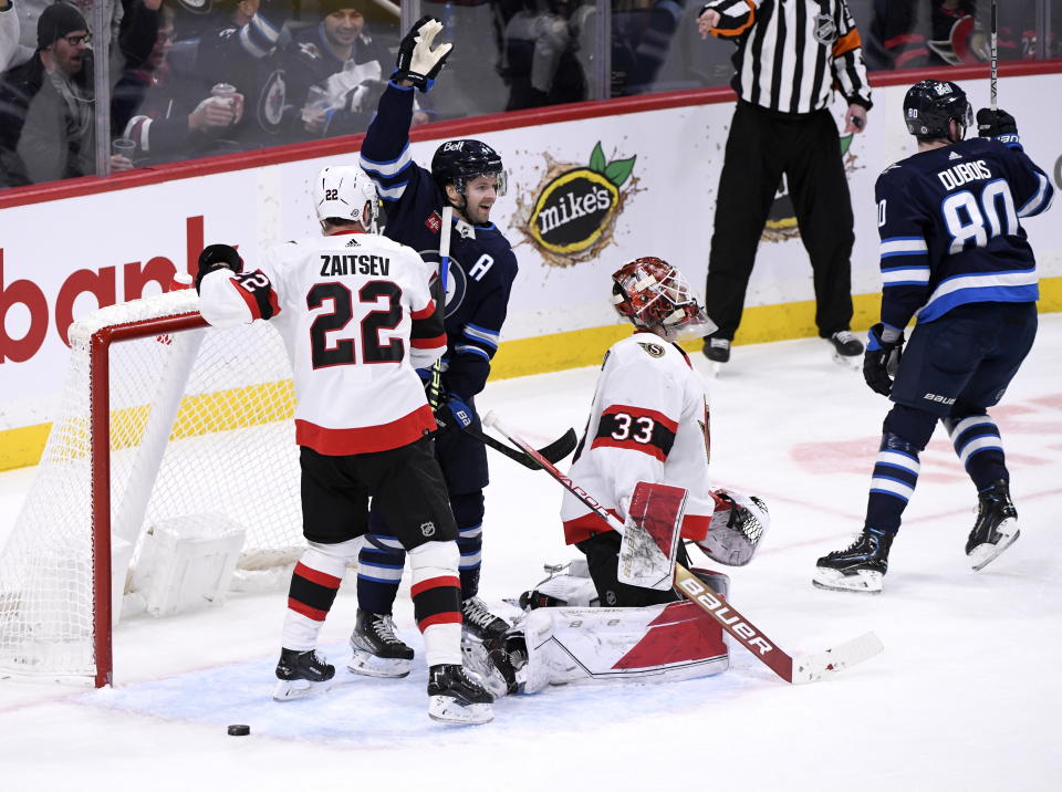 Winnipeg Jets' Josh Morrissey (44) celebrates a goal by Sam Gagner, not seen, on Ottawa Senators goaltender Cam Talbot (33) during the first period of an NHL hockey game Tuesday, Dec. 20, 2022, in Winnipeg, Manitoba. (Fred Greenslade/The Canadian Press via AP)