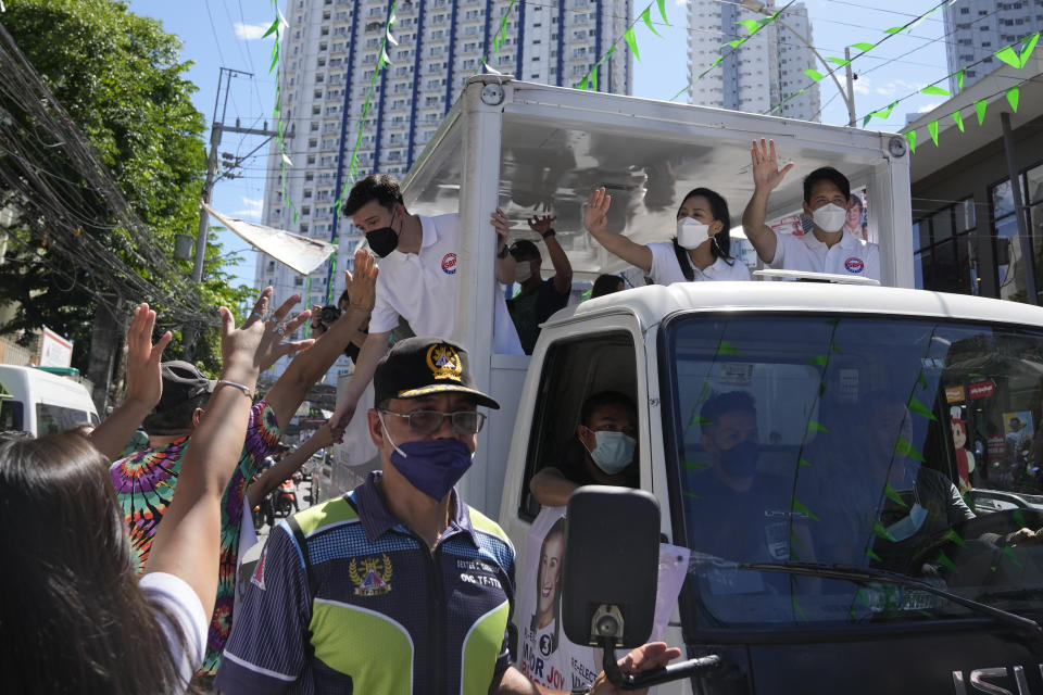 Quezon City Mayor Joy Belmonte, center, waves during a motorcade as she starts her re-election campaign in Quezon City, Philippines on Friday, March 25, 2022. Candidates for thousands of provincial, town and congressional posts started campaigning across the Philippines Friday under tight police watch due to a history of violent rivalries and to enforce a lingering pandemic ban on handshakes, hugging and tightly packed crowds that are a hallmark of often circus-like campaigns. (AP Photo/Aaron Favila)