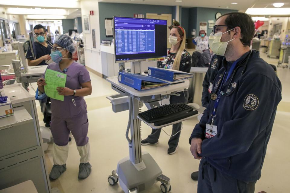 Dr. Curtis Converse, right, on his morning rounds, visits with COVID patients at Arrowhead Regional Medical Center