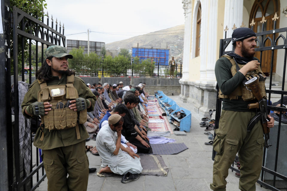 Afghan people offer Eid al-Fitr prayers as Taliban fighters stand guard at a mosque in Kabul, Afghanistan, Wednesday, June 28, 2023. Muslims celebrate the holiday to mark the willingness of the Prophet Ibrahim (Abraham to Christians and Jews) to sacrifice his son. During the holiday, they slaughter sheep or cattle, distribute part of the meat to the poor and eat the rest. (AP Photo/Siddiqullah Khan)