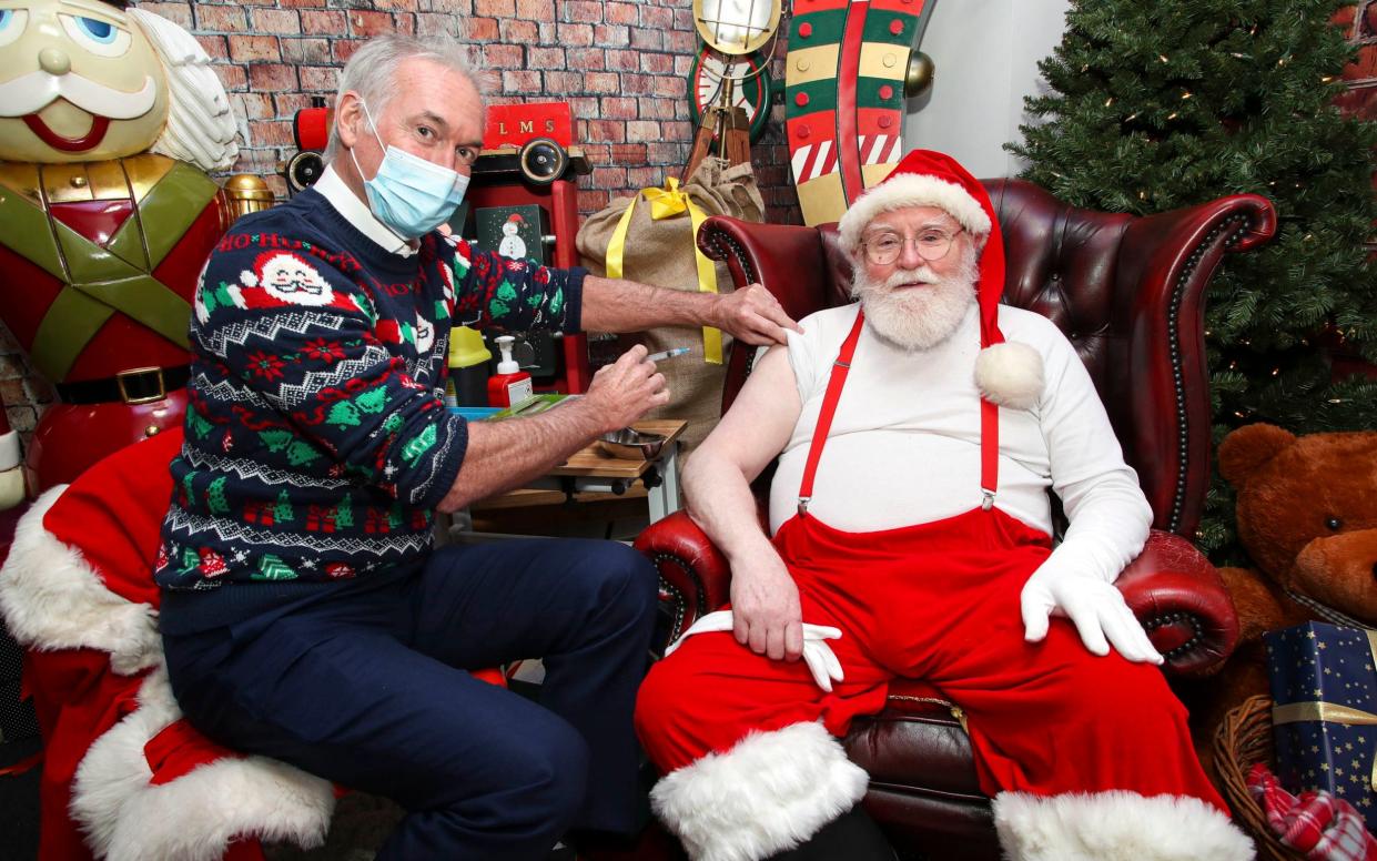 A santa from the Ministry of Fun, London’s leading santa school, receives a Covid booster jab - Kieran Cleeves/PA