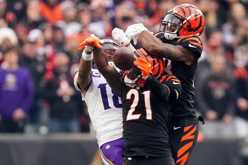 Cincinnati Bengals cornerback Mike Hilton (21) and Cincinnati Bengals safety Dax Hill (23) break up a pass intended for Minnesota Vikings wide receiver Justin Jefferson (18) in the fourth quarter of a Week 15 NFL football game between the Minnesota Vikings and the Cincinnati Bengals, Saturday, Dec. 16, 2023, at Paycor Stadium in Cincinnati. The Cincinnati Bengals won 27-24 in overtime.