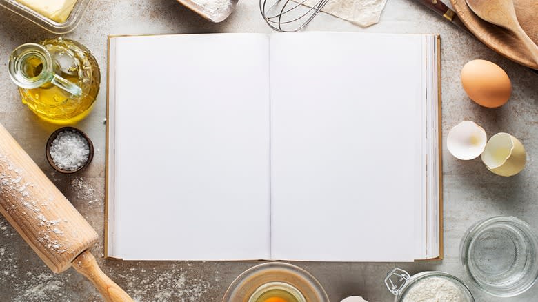 Baking ingredients surrounding recipe book