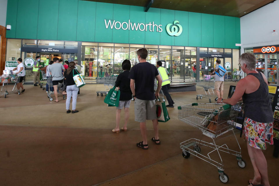 People stand in line outside a Woolworths at a southern suburb of Brisbane. Source: Getty Images