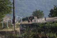 Armenian children play next to the new Armenian-Azerbaijani border in Shurnkh village, about 200 km. (125 miles) south-east of Yerevan, Armenia, Tuesday, June 15, 2021. The village was cut in two by a newly defined border with Azerbaijan, and she lost her house in the peace deal. (AP Photo/Areg Balayan)