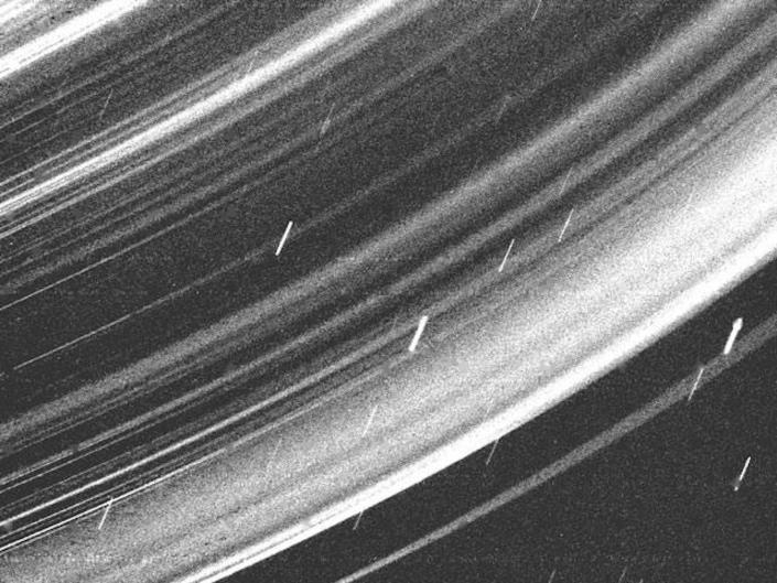 The grainy black and white image shows a close-up of Uranus' rings.