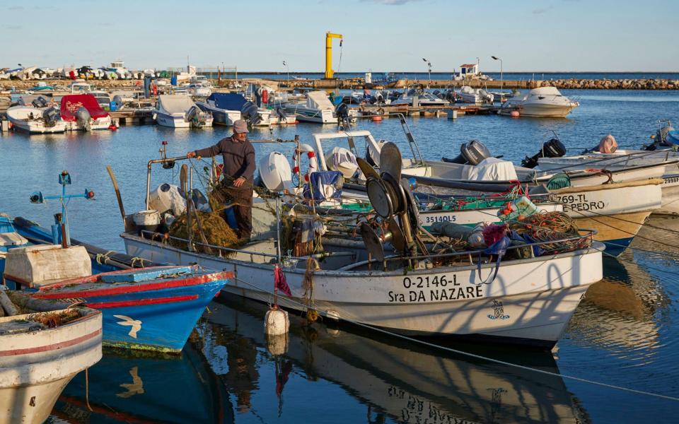 Fishing boat and a fisherman in the port of Olhao, Portugal