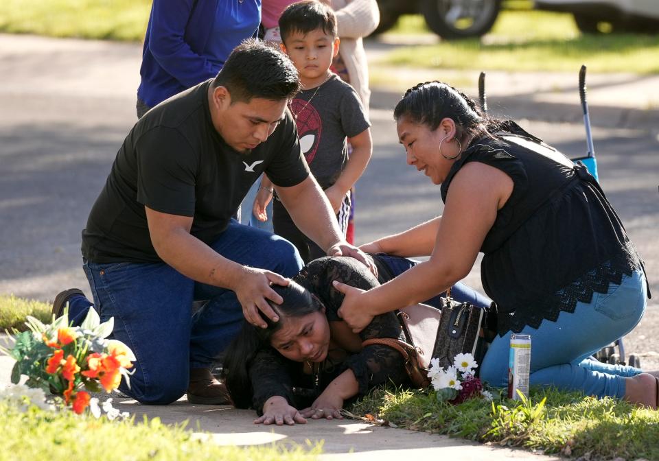 Domitilia Caal Pop is consoled Dec. 6 by her brother, Cornelio Caal, and sister, Filomena Caal, at the site on Shadywood Lane in South Austin where her husband, Emmanuel Pop Ba, was killed the previous day.