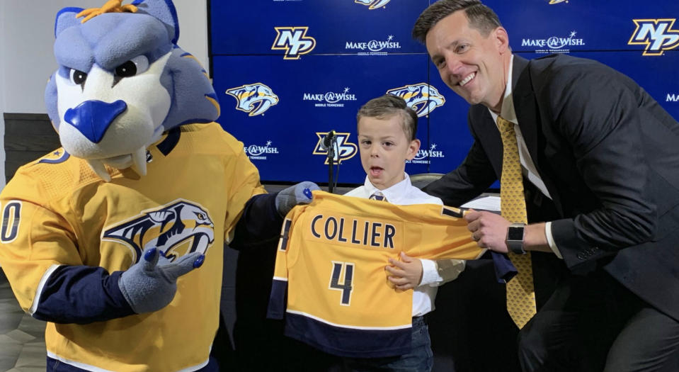 Asher Collier (middle) poses alongside Gnash, the mascot of the Nashville Predators, and Brian Poile, the team’s assistant general manager, after signing with the organization. (Twitter//@PredsNHL)