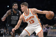 Atlanta Hawks guard Bogdan Bogdanovic (13) drives against Brooklyn Nets forward Royce O'Neale (00) during the first half of an NBA basketball game Friday, Dec. 9, 2022, in New York. (AP Photo/Mary Altaffer)