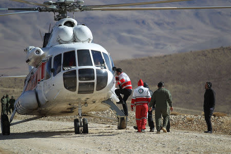 Members of emergency and rescue team search for the plane that crashed in a mountainous area of central Iran, February 19, 2018. REUTERS/Tasnim News Agency