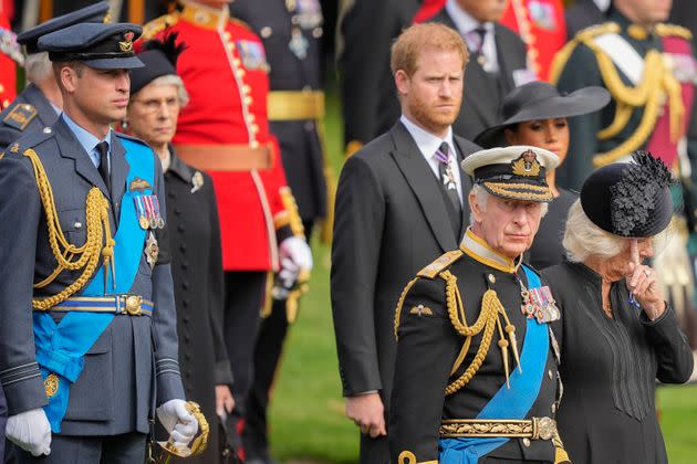 King Charles III, from right, Camilla, the Queen Consort, Meghan, Duchess of Sussex, Prince Harry and Prince William watch as the coffin of Queen Elizabeth II is placed into the hearse following the state funeral service in Westminster Abbey in central London.