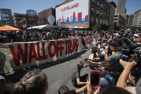 Anti-Trump protesters hold a banner during the Republican National Convention in Cleveland, Ohio, U.S. July 21, 2016. REUTERS/Jim Urquhart