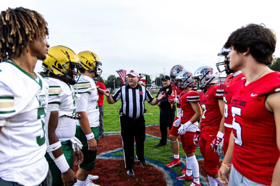 Iowa City West and Iowa City High captains meet at midfield for the coin toss during a Class 5A high school football game in the Battle for the Boot, Friday, Sept. 15, 2023, at Frank Bates Field in Iowa City, Iowa. City High won, 23-8.