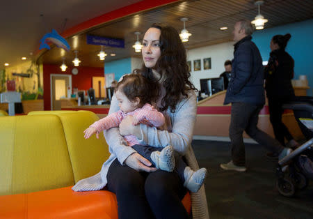 Nancy Minoui holds her 9 month old daughter Marion Burgess, who suffers from a chronic heart condition, in a waiting room at the Dornbecher Children's hospital in Portland, Oregon, U.S. December 6, 2017. Picture taken December 6, 2017. REUTERS/Natalie Behring