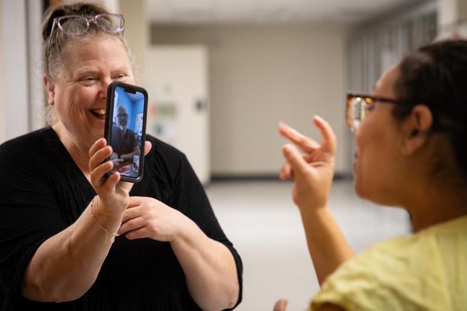 Charlene Scott, a community relations specialist, holds her phone up so Alex Peña, an interpreter, can sign to Jaime Lugo, the executive director, at the Deaf and Hard of Hearing Center, on Wednesday, Oct. 25, 2023, in Corpus Christi, Texas.