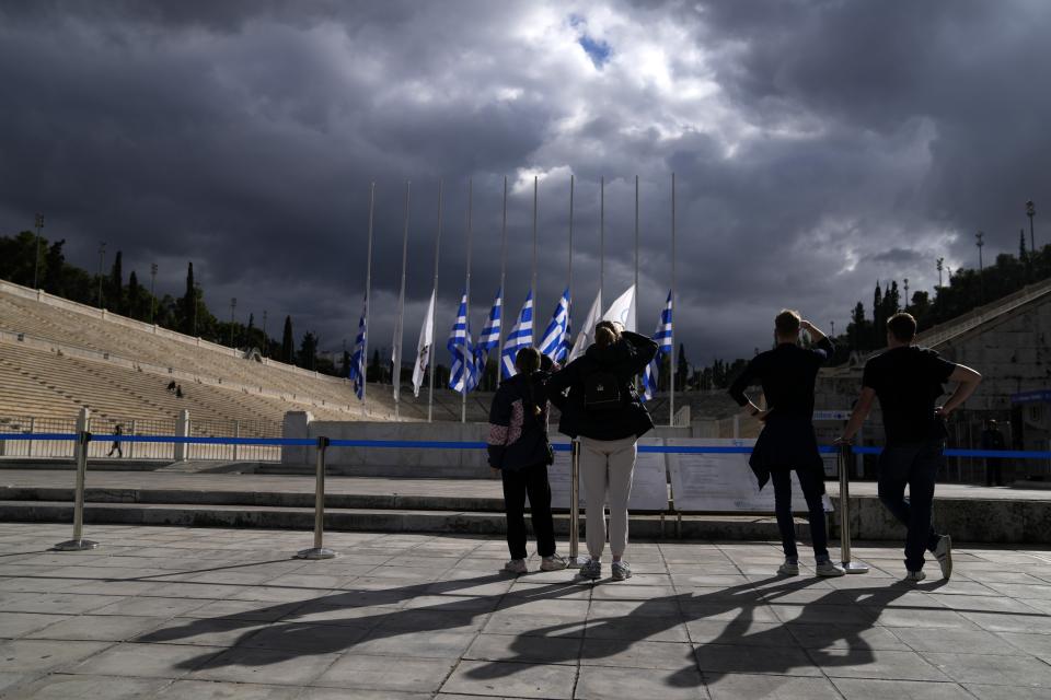 Greek and Olympic flags are seen at half-staff as the Hellenic Olympic Committee commemorate the former king of Greece who was an Olympic sailing gold medalist in Rome in 1960, at Panathinean stadium in Athens, Greece, Wednesday, Jan. 11, 2023. Greece's government says Constantine, the former and last king of Greece, will be buried as a private citizen in Tatoi, the former summer residence of Greece's royals where his parents and ancestors are buried. (AP Photo/Thanassis Stavrakis)