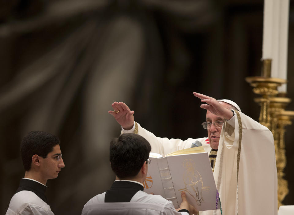 Pope Francis presides over an Easter vigil service in St. Peter's Basilica, at the Vatican Saturday, April 19, 2014. Pope Francis baptized 10 people Saturday as he presided over an Easter Vigil in St. Peter's Basilica, fulfilling a ritual deep in meaning on the most solemn night of the Catholic calendar. Francis urged the priests, bishops, cardinals and ordinary Catholics gathered for the late night service to remember when they first found their faith. "Do I remember it? Have I forgotten it? Look for it. You'll find it. The Lord is waiting." (AP Photo/Alessandra Tarantino)