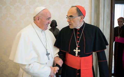Pope Francis shaking hands with France's Cardinal Philippe Barbarin - Credit: AFP