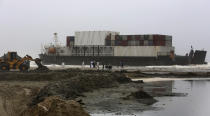 Officials of the Karachi Port Trust and Pakistan Navy prepare to conduct an operation for refloating the stranded Heng Tong 77 cargo ship at Sea View Beach near the southern port city of Karachi, Pakistan, Monday, July 26, 2021. Pakistani authorities said they are working on plans to refloat the cargo ship that ran aground last week amid bad weather en route to Istanbul from China. (AP Photo/Fareed Khan)