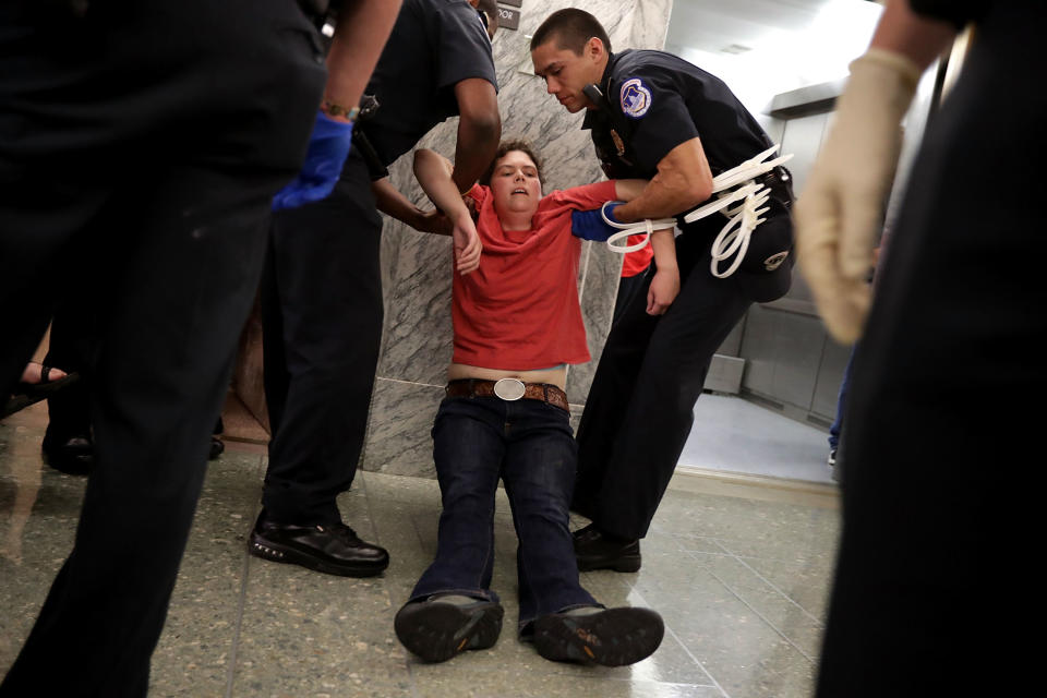 <p>U.S. Capitol Police arrest protesters who shouted and interrupted a Senate Finance Committee hearing about the proposed Graham-Cassidy Healthcare Bill in the Dirksen Senate Office Building on Capitol Hill September 25, 2017 in Washington, DC. Demonstrators disrupted the hearing to protest the legislation, the next in a series of Republican proposals to replace the Affordable Care Act, also called Obamacare. (Photo: Chip Somodevilla/Getty Images) </p>