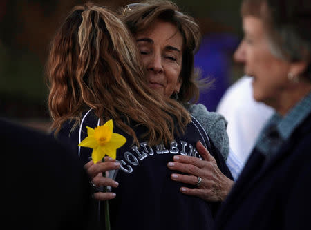 Dawn Anna, mother of Lauren Townsend, killed in the Columbine high school attack, hugs a visitor in a Columbine jacket at the Columbine memorial a day before the school shooting's 20th anniversary, in Littleton, Colorado, U.S., April 19, 2019. REUTERS/Rick Wilking