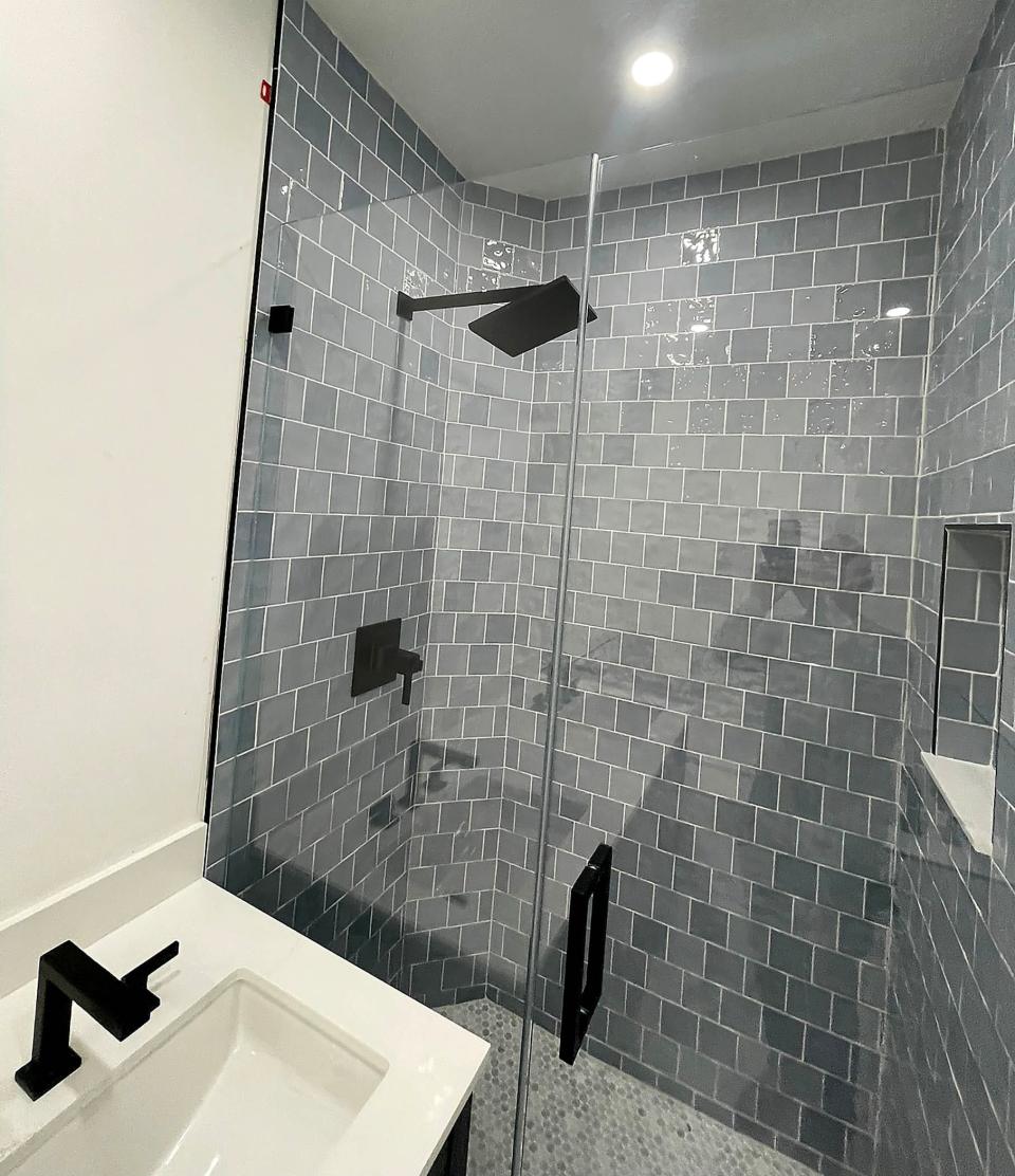 "After" photo of a bathroom remodel/renovation highlighting popular gray tiles.