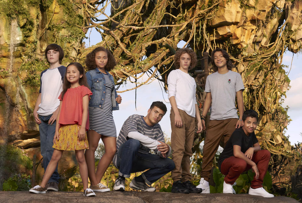 New <i>Avatar</i> cast pose at Pandora: The World of Avatar attraction in Disney’s Animal Kingdom theme park in Orlando. L-R: Jack Champion (Javier ‘Spider’ Socorro), Trinity Bliss (Tuktirey of the Sully Family), Bailey Bass (Tsireya of the Metkayina Clan), Jamie Flatters (Neteyam of the Sully Family), Britain Dalton (Loâak of the Sully Family), Filip Geljo (Aonung of the Metkayina Clan), and Duane Evans Jr (Rotxo of the Metkayina Clan). (Photo Credit: Sheryl Nields/20th Century Fox)