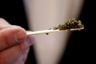 FILE PHOTO: An employee shows off caviar at a shop in Paris