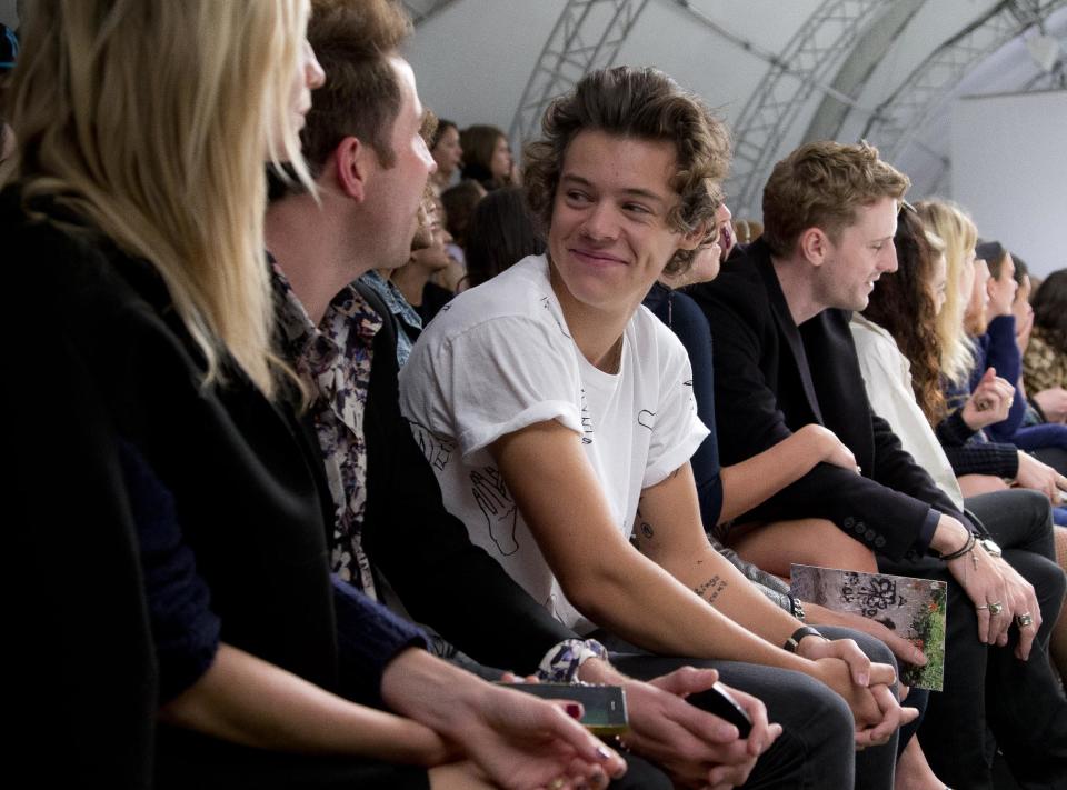 Harry Styles of British band One Direction, right, chats to friend and British Radio One DJ Nick Grimshaw as they watch the Fashion East show during London Fashion Week Spring/Summer 2014, in Regent's Park, central London, Tuesday, Sept. 17, 2013. (Photo by Joel Ryan/Invision/AP)