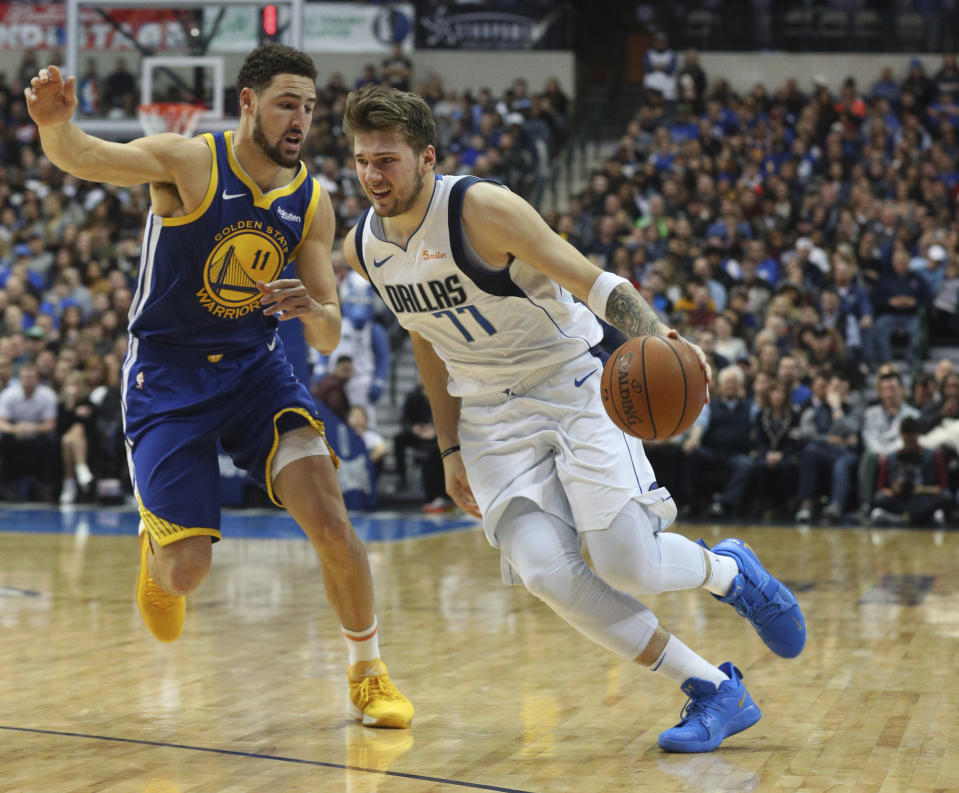 Golden State Warriors guard Klay Thompson (11) defends as Dallas Mavericks guard Luka Doncic (77) drives past in the second half of an NBA basketball game Sunday, Jan. 13, 2019, in Dallas. The Warriors won, 119-114. (AP Photo/Richard W. Rodriguez)