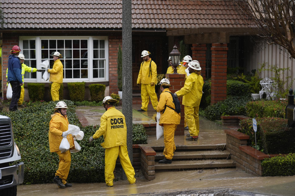 California Department of Corrections prisoners help sandbag homes along Gotera Drive in the Hacienda Heights section of Los Angeles on Tuesday, Feb. 6, 2024. (AP Photo/Marcio Jose Sanchez)