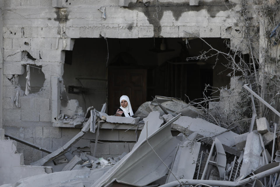 A Palestinian woman looks out of her window after an Israeli strike on the Gaza Strip in Rafah on Saturday, Oct. 21, 2023. (AP Photo/Hatem Ali)