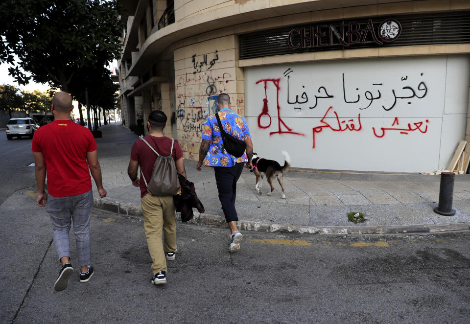 A damaged closed shop with Arabic graffiti written by protesters reads: “You literally blew us up. We shall live to kill you,” in Beirut, Lebanon, Feb. 2, 2021. The blast was one of the largest non-nuclear explosions in history and six months later, political and confessional rivalries have undermined the probe into the Beirut port explosion and brought it to a virtual halt, mirroring the same rivalries that have thwarted past attempts to investigate political crimes throughout Lebanon's history. (AP Photo/Hussein Malla)