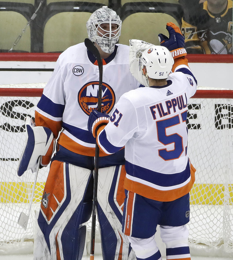 New York Islanders goaltender Robin Lehner (40) celebrates with Valtteri Filppula at the end of Game 4 of the team's NHL hockey first-round playoff series against the Pittsburgh Penguins in Pittsburgh, Tuesday, April 16, 2019. The Islanders won 3-1, and swept the series. (AP Photo/Gene J. Puskar)