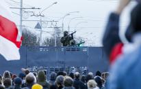 Belarusian riot police stand guard on top of a police barricade blocking a street during an opposition rally to protest the official presidential election results in Minsk, Belarus, Sunday, Oct. 25, 2020. The demonstrations were triggered by official results giving President Alexander Lukashenko 80% of the vote in the Aug. 9 election that the opposition insists was rigged. Lukashenko, who has ruled Belarus with an iron fist since 1994, has accused the United States and its allies of fomenting unrest in the ex-Soviet country. (AP Photo)