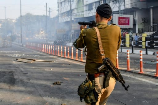 A security officer fires tear gas during a curfew in Guwahati, Assam on December 12, 2019