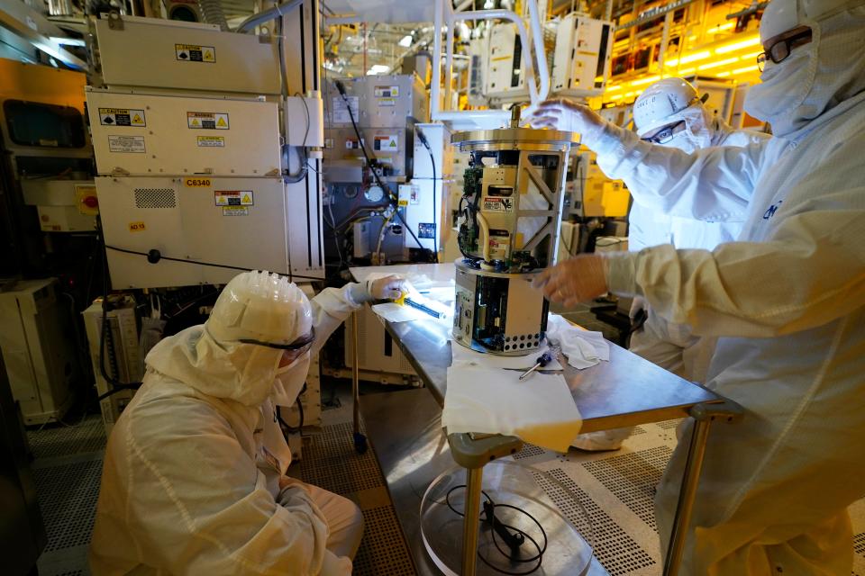 Technicians inspect a piece of equipment during a tour of the Micron Technology automotive chip manufacturing plant on Feb. 11, 2022, in Manassas, Va. A bill to boost semiconductor production in the United States is making its way through the Senate is a top priority of the Biden administration. It would add about $79 billion to the deficit over 10 years, mostly as a result of new grants and tax breaks that would subsidize the cost that computer chip manufacturers incur when building or expanding chip plants in the U.S.