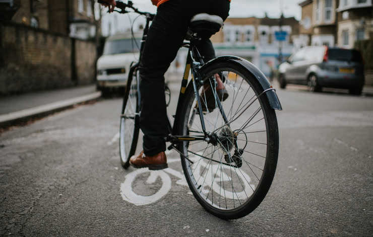 Person on bicycle stopped at bike lane marking on a city street