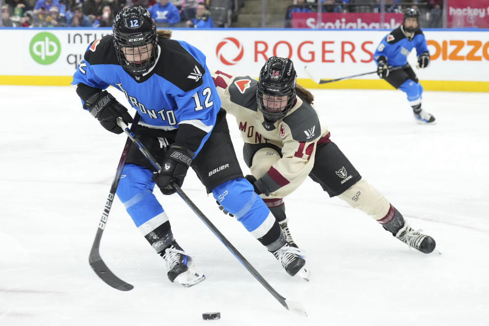 Toronto's Allie Munroe, left, vies for the puck against Montreal's Jillian Dempsey during the second period of a PWHL hockey game Friday, Feb. 16, 2024, in Toronto. (Chris Young/The Canadian Press via AP)