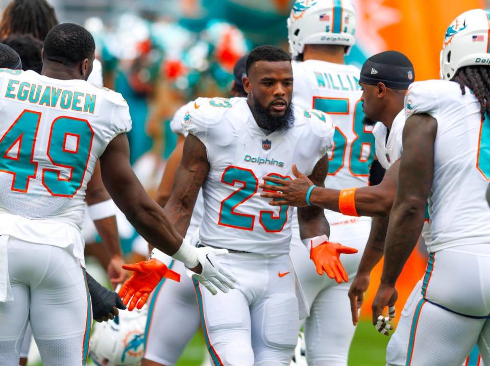 Miami Dolphins running back Jeff Wilson Jr. (23) high five teammates before the start of an NFL football game against the Houston Texans at Hard Rock Stadium on Sunday, November 27, 2022 in Miami Gardens, Florida.